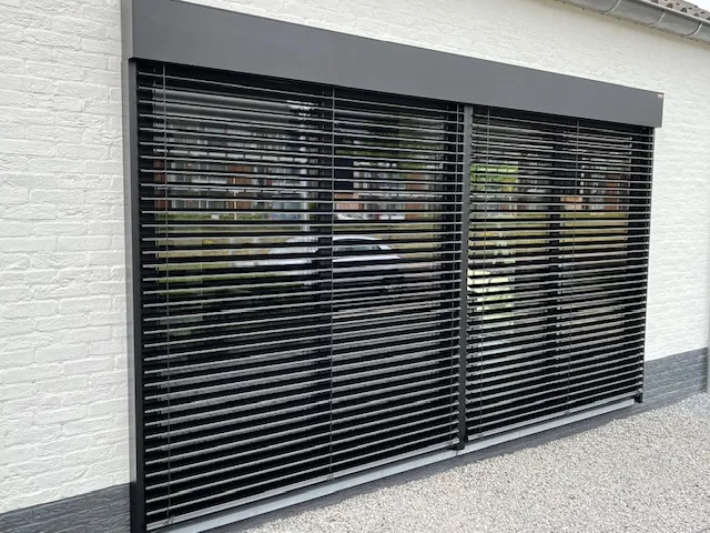 Zonwering aan de gevel van een woning, uitgeklapt om schaduw te creëren en de binnenruimte te beschermen tegen warmte.