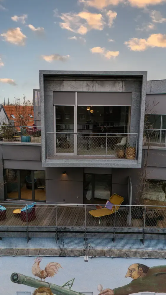 Moderne woning met balkon en grijze screens voor grote ramen. | Zonwering.nl